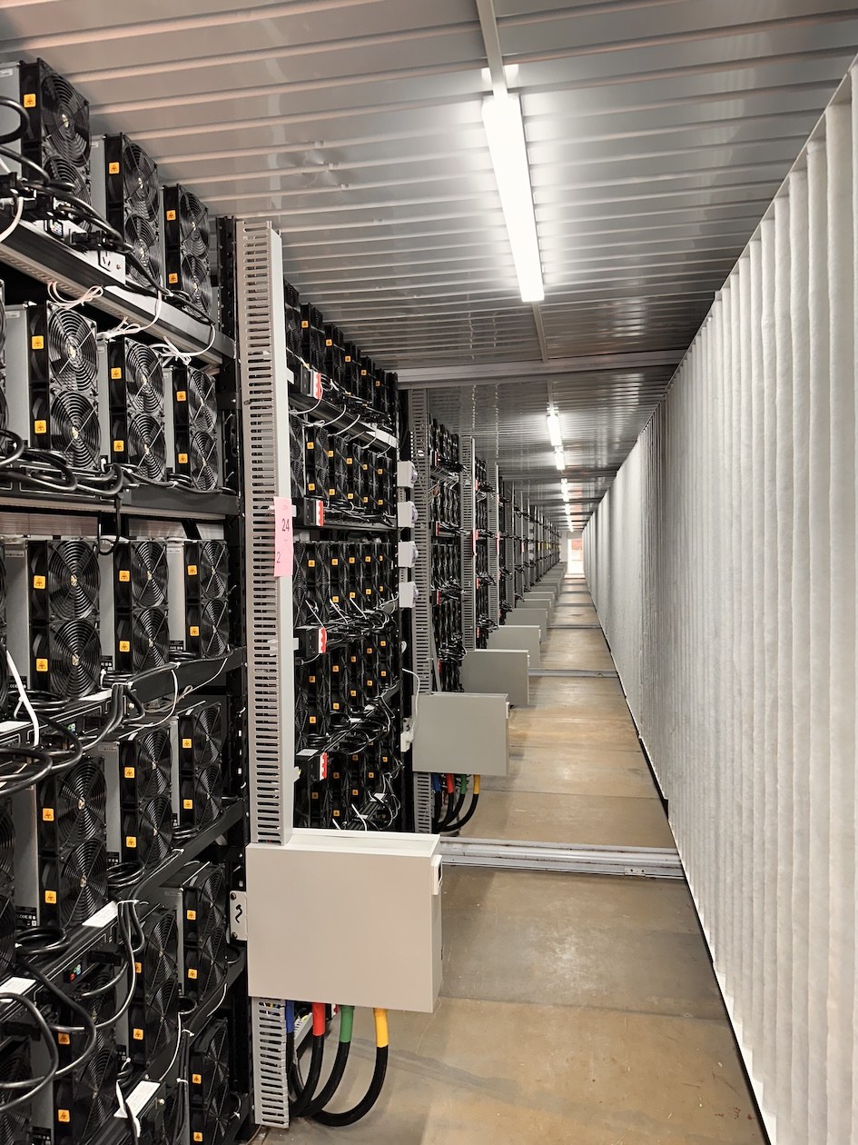 Rows of ASIC computers inside a mining facility